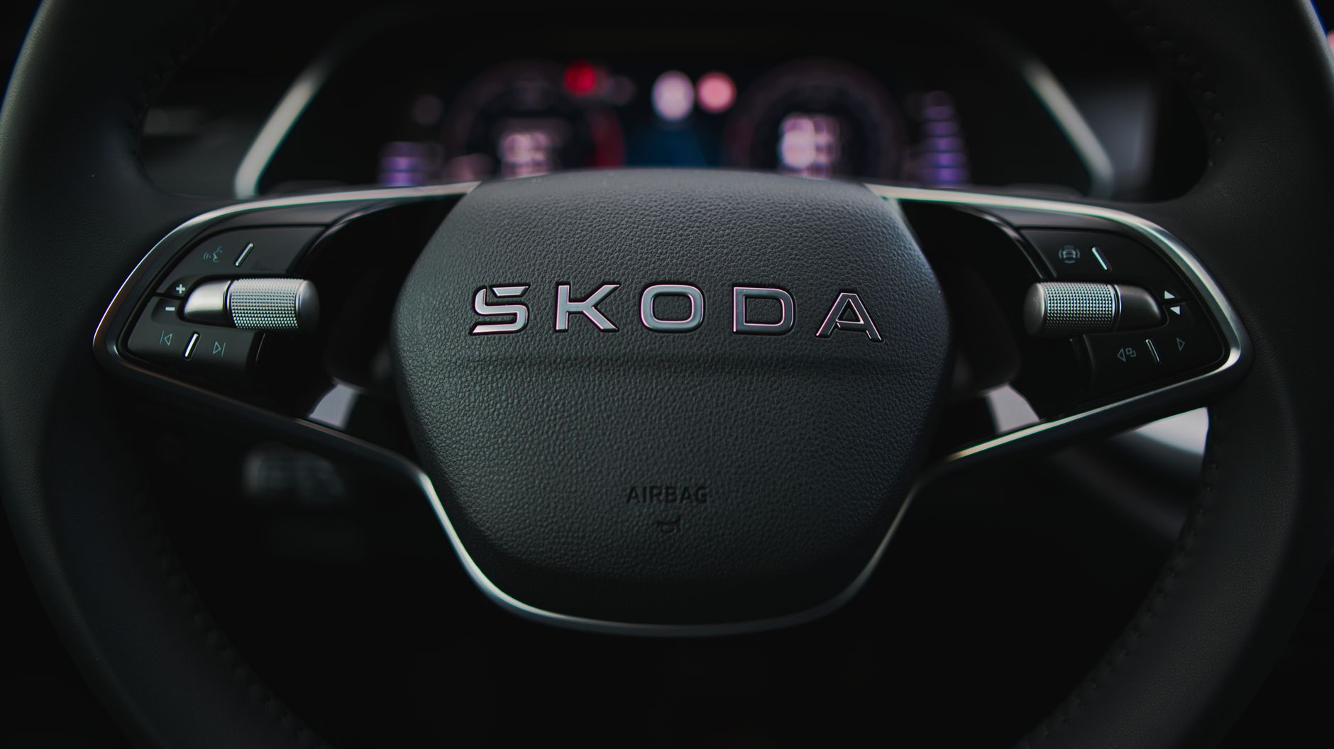 Detailed image of a Škoda steering wheel highlighting controls and dashboard.