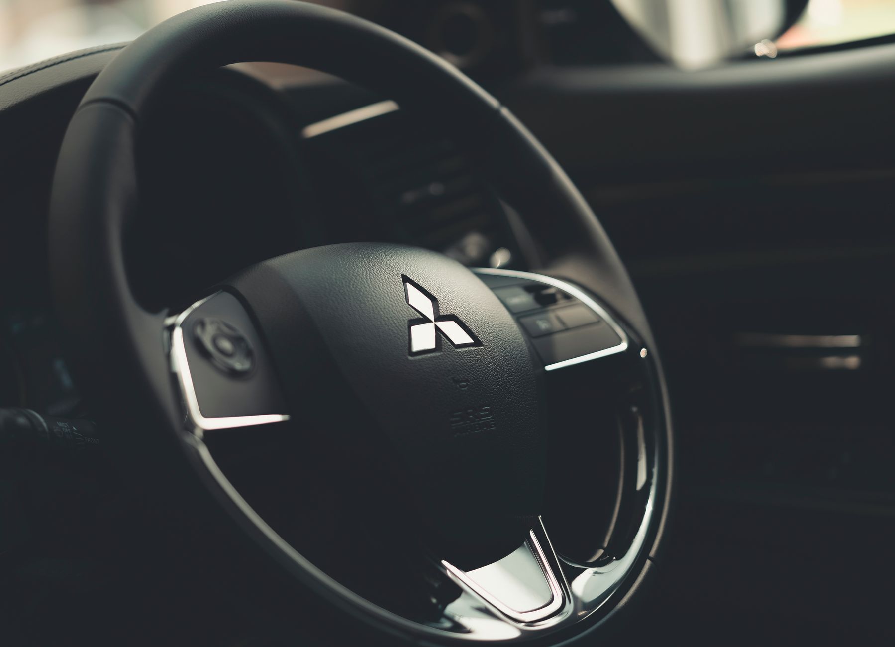 Intricate details of a Mitsubishi steering wheel with a focus on texture and design.