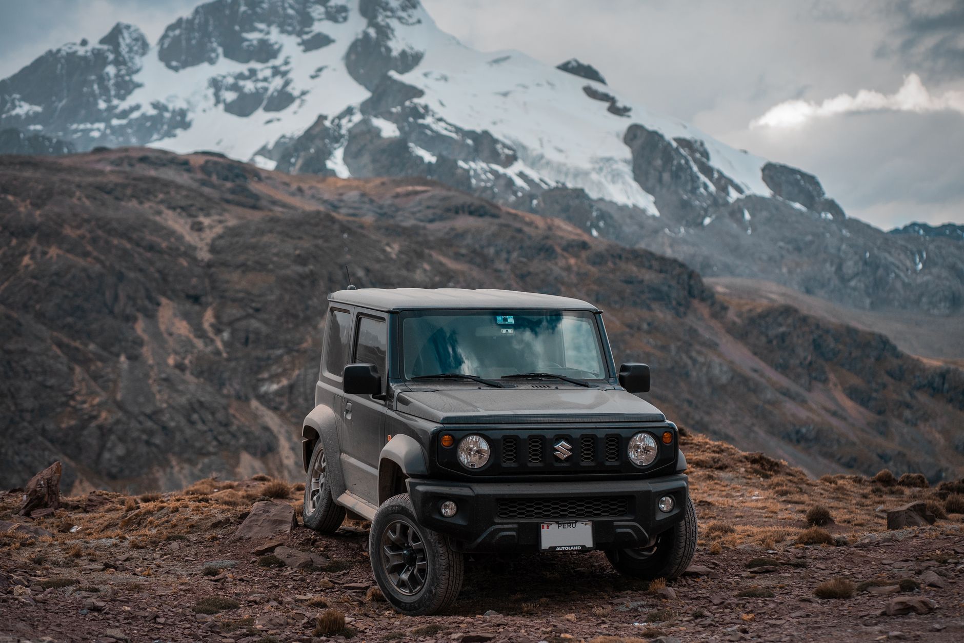 Explore the rugged terrain of Peru's mountains with a Suzuki Jimny, showcasing adventure and scenic landscapes.