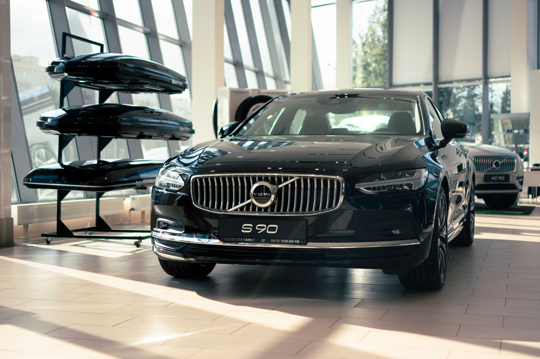 Elegant Volvo S90 on display in a modern car showroom with bright lighting and contemporary design.