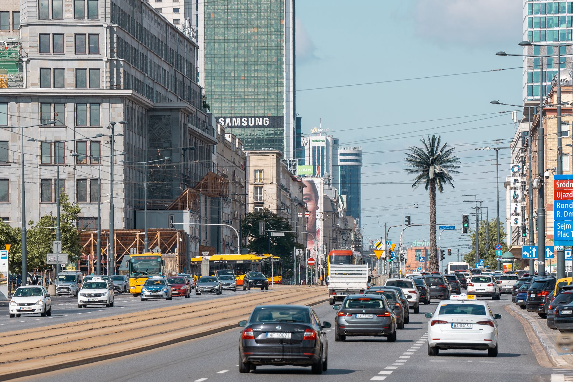 Vibrant city street in Warsaw, showcasing traffic, urban architecture, and bustling life.