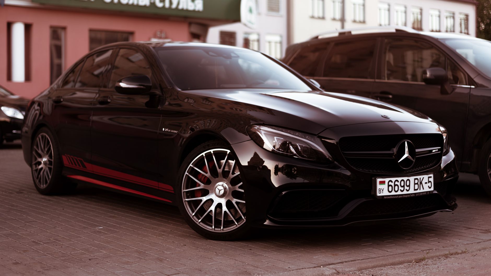 A stylish black Mercedes C-Class vehicle parked on urban pavement, showcasing luxury design.
