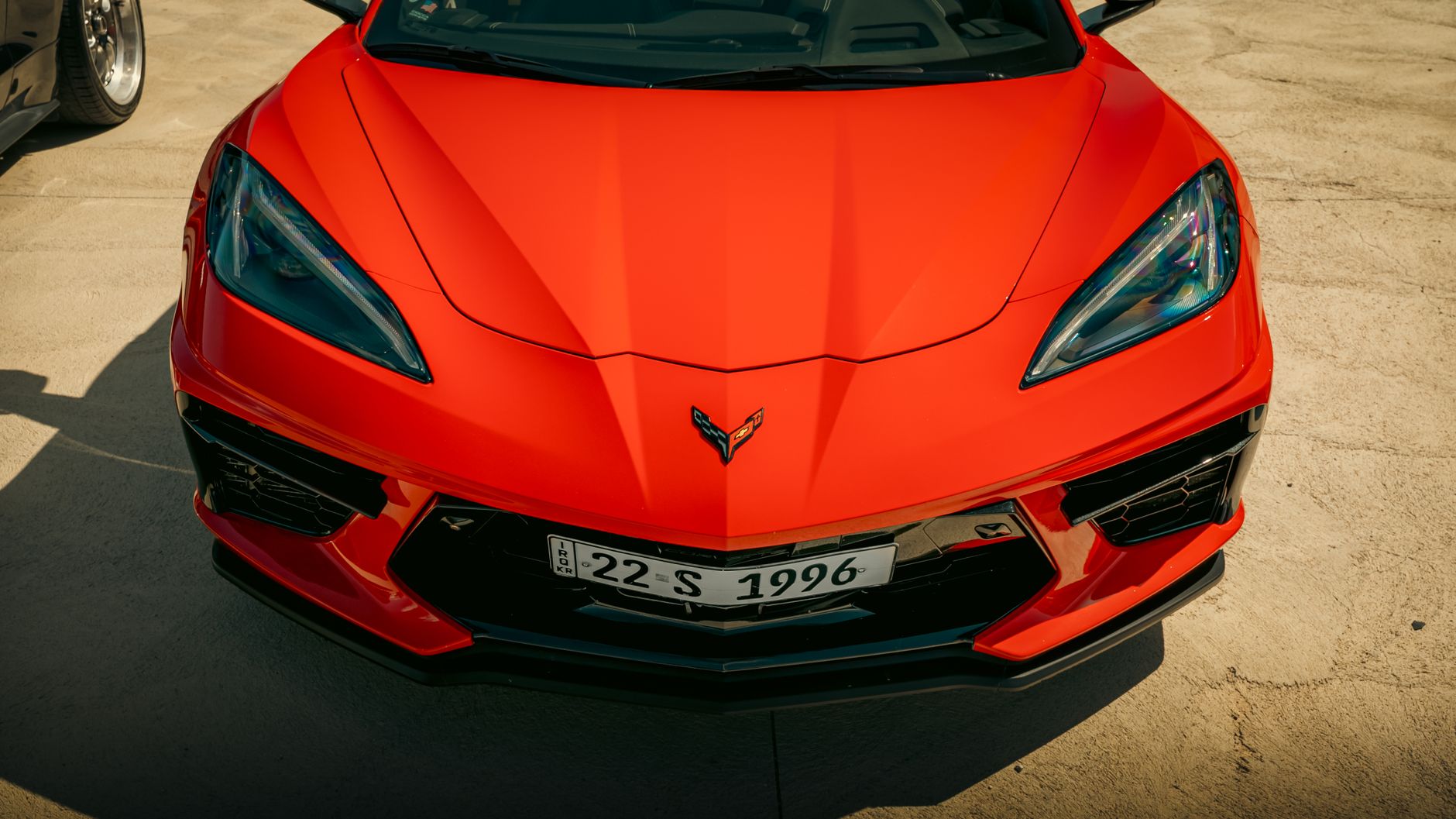 Dramatic front view of a sleek red sports car emphasizing its dynamic design and glossy finish.