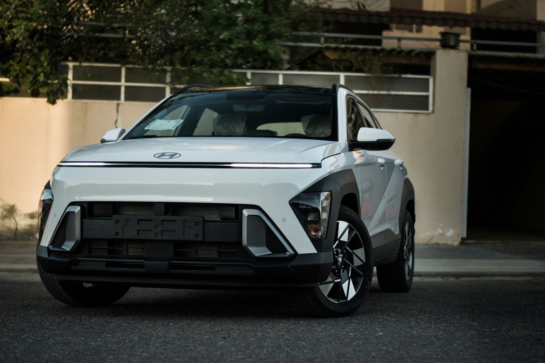 Front view of a modern white SUV parked outdoors on urban street.