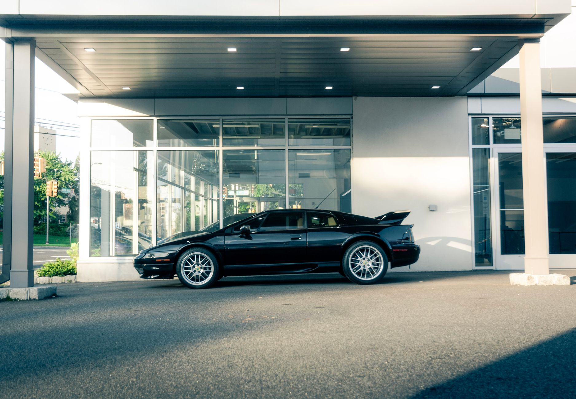 Elegant black sports car parked in a modern automotive showroom, highlighting its design features.