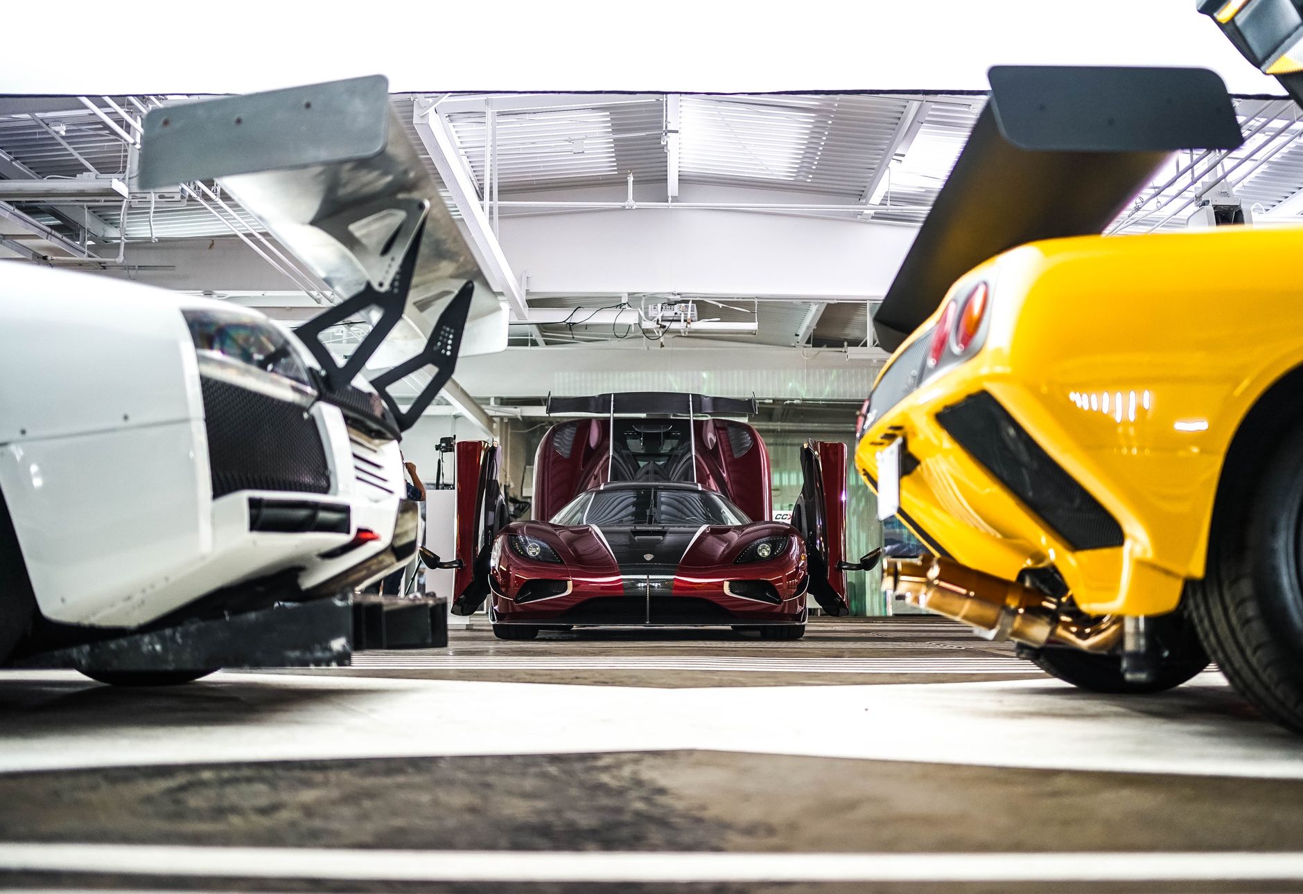 Vibrant supercars in a modern, well-lit garage showcasing sleek designs and engineering.