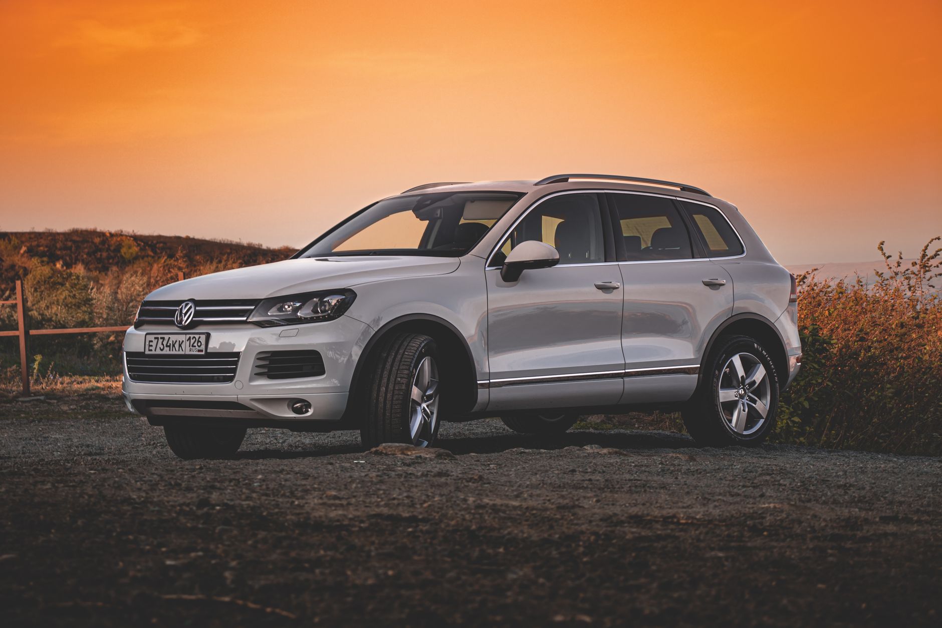 Stylish white Volkswagen SUV parked outdoors during a vibrant sunset, showcasing modern automotive design.